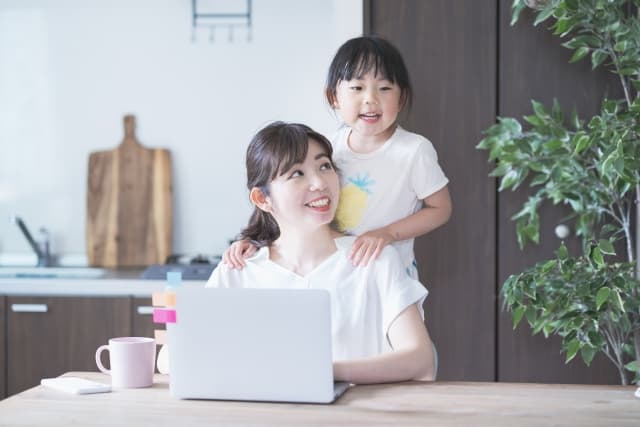 子どもと一緒にパソコンへ向かうお母さん