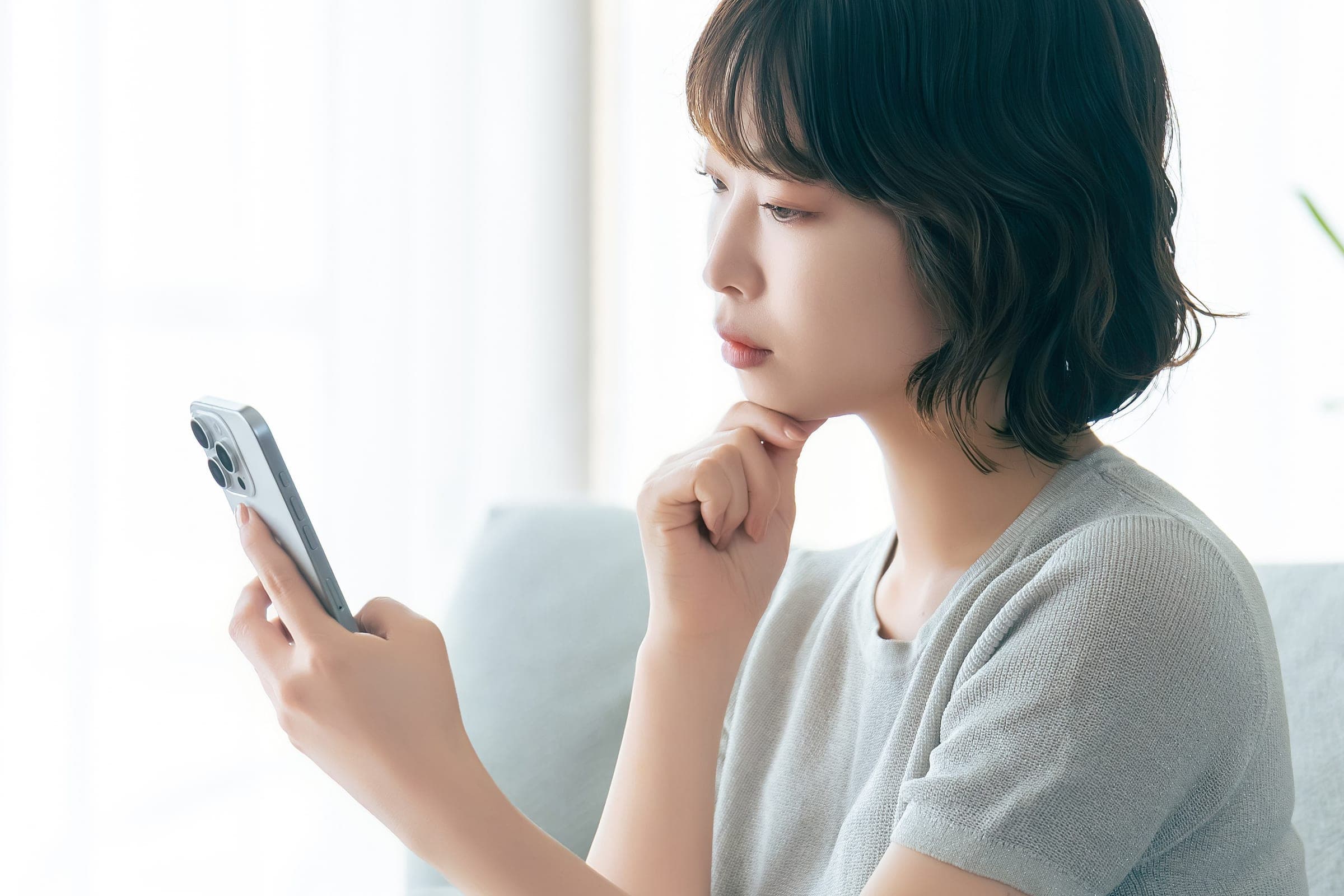 スマートフォンで相談するお母さん